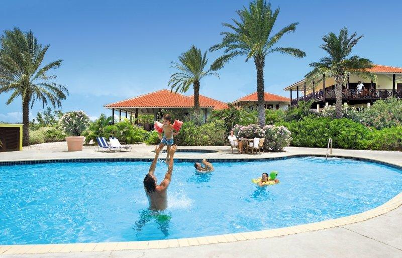 Familie, die am Pool des Blue Bay Curacao Golf & Beach Resorts Spaß hat