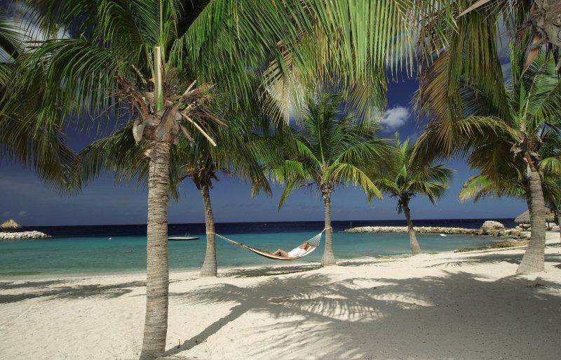 Person in einer Hängematte am Strand des Blue Bay Curacao Golf & Beach Resorts