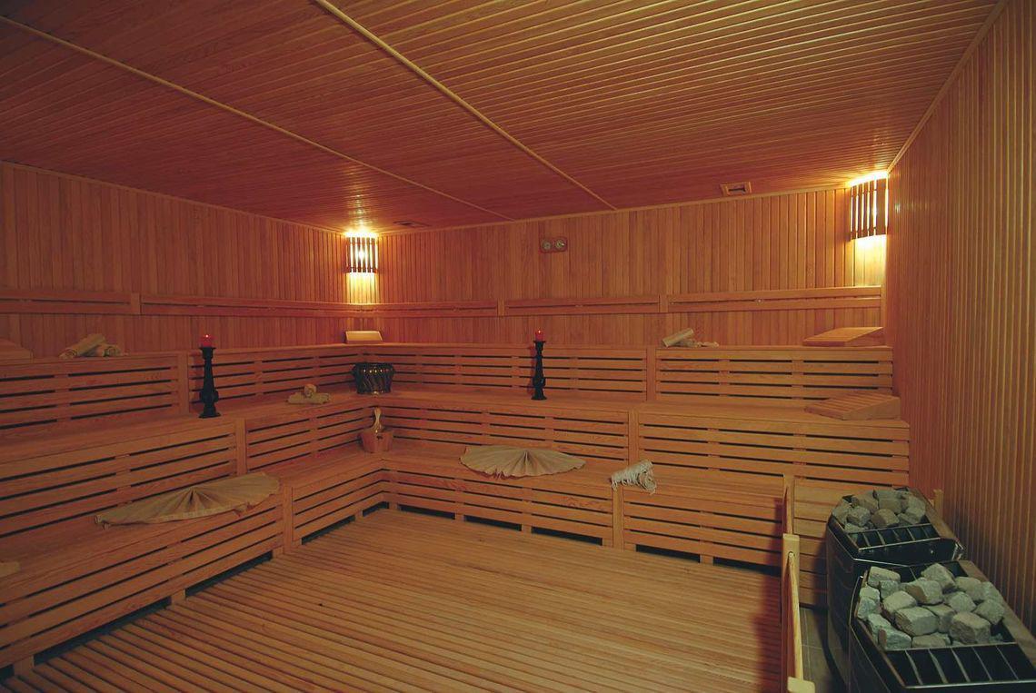 Saunaraum im Commodore Elite Suites & Spa mit Holzwänden und Bänken.