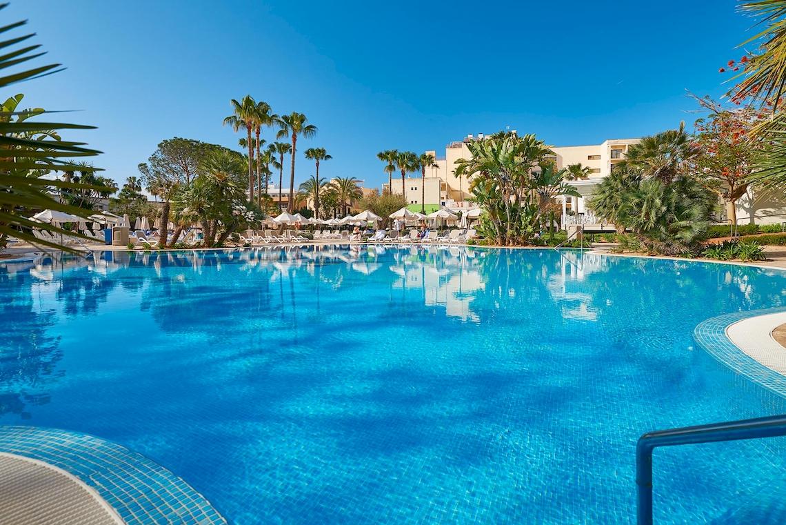 Außenpool des Hipotels Said Strand Hotels mit Sonnenliegen und Palmen