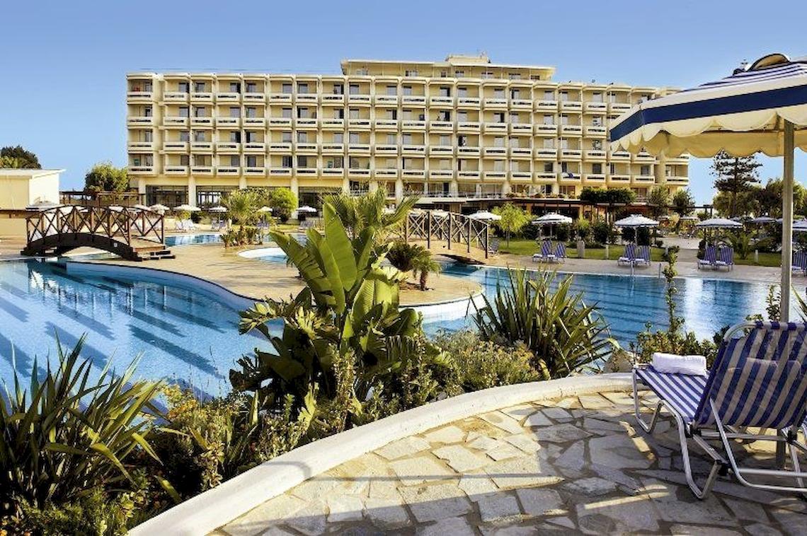 Electra Palace Rhodes Hotel mit Swimmingpool und Liegestühlen im Freien.