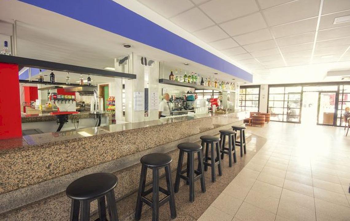 Barbereich des Azuline Hotel Mar Amantis mit Theke, Stühlen und offenen Türen.