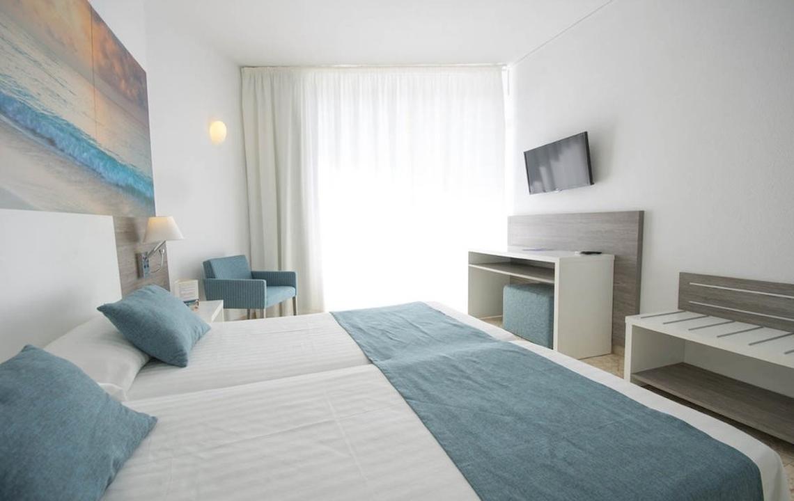 Doppelbettzimmer im Azuline Hotel Mar Amantis mit Fernseher, Stuhl und Schreibtisch.