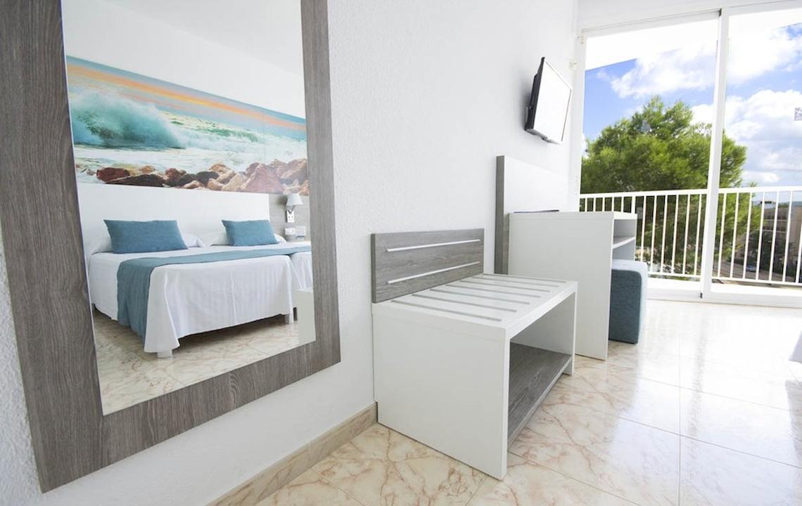 Innenansicht eines Zimmers im Azuline Hotel Mar Amantis mit einem Bett, Spiegel und Balkon.