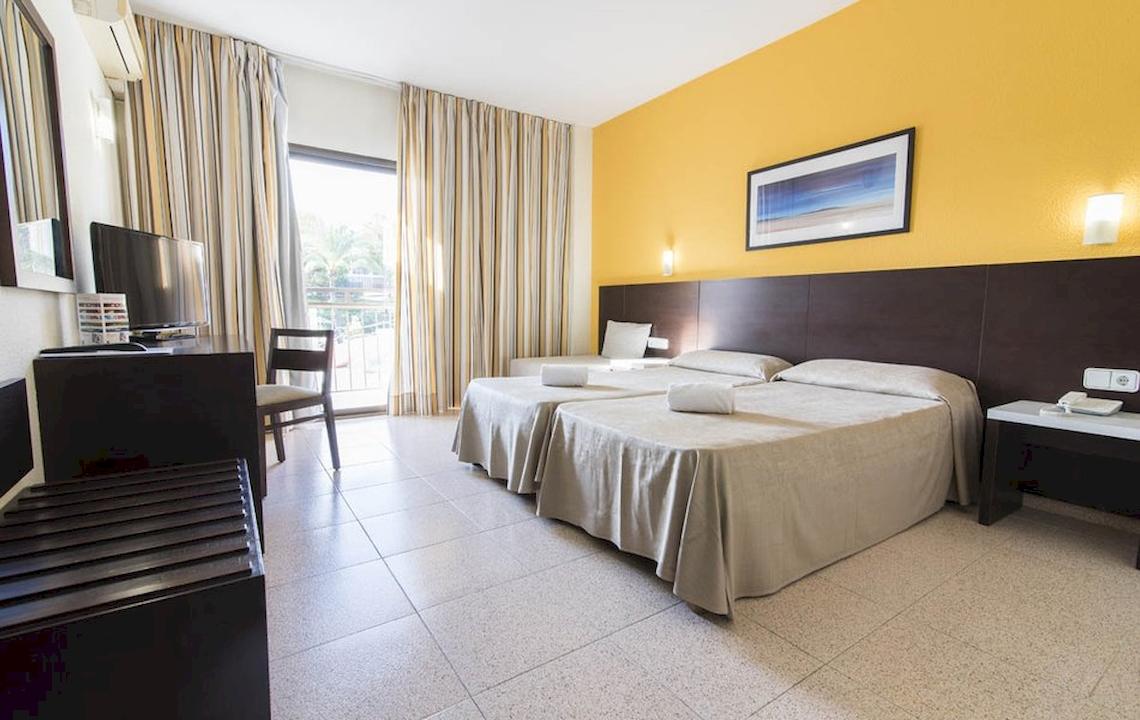 Innenansicht eines Doppelzimmers im Azuline Hotel Mar Amantis mit zwei Betten, Fernseher, Schreibtisch und Balkon