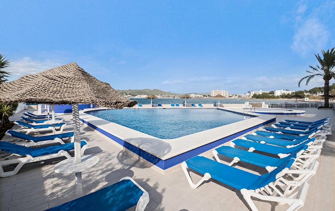 Außenpool des Azuline Hotel Mar Amantis mit blauen Liegen und Sonnenschirmen.