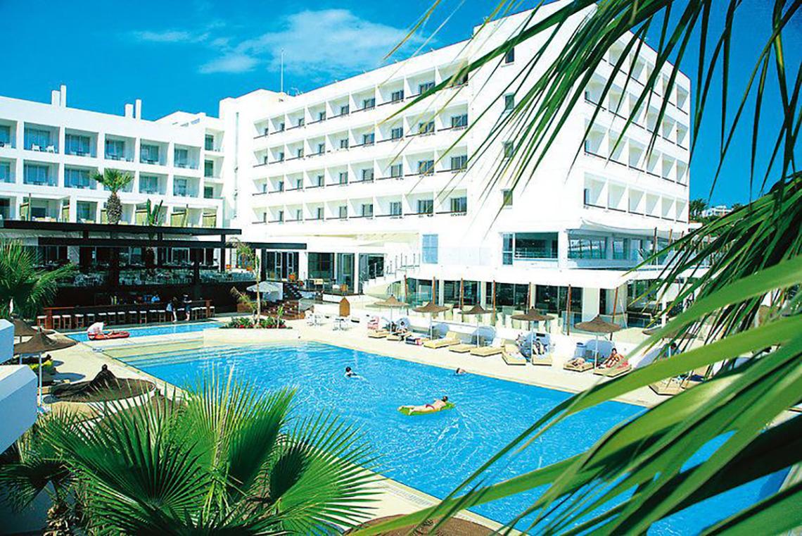 Außenbereich des Napa Mermaid Hotel & Suites mit Pool, Liegestühlen und Sonnenschirmen.