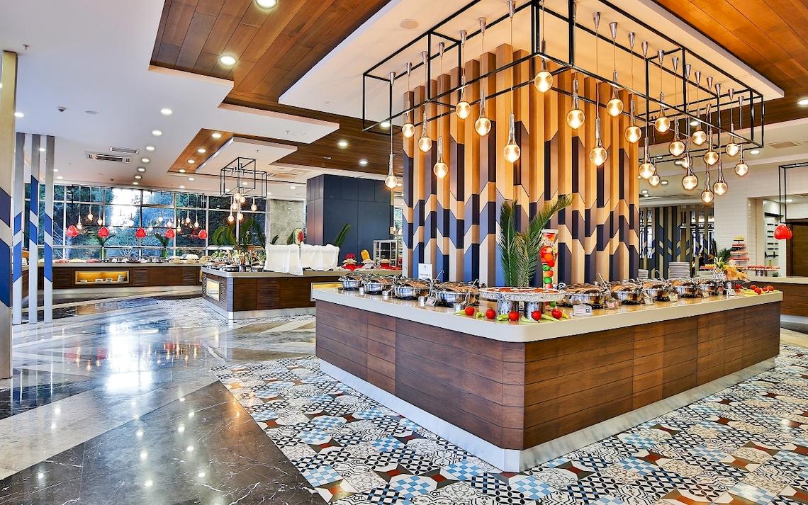 Buffet-Bereich im Saturn Palace Resort mit farbenfrohem Dekor und verschiedenen Speisen.