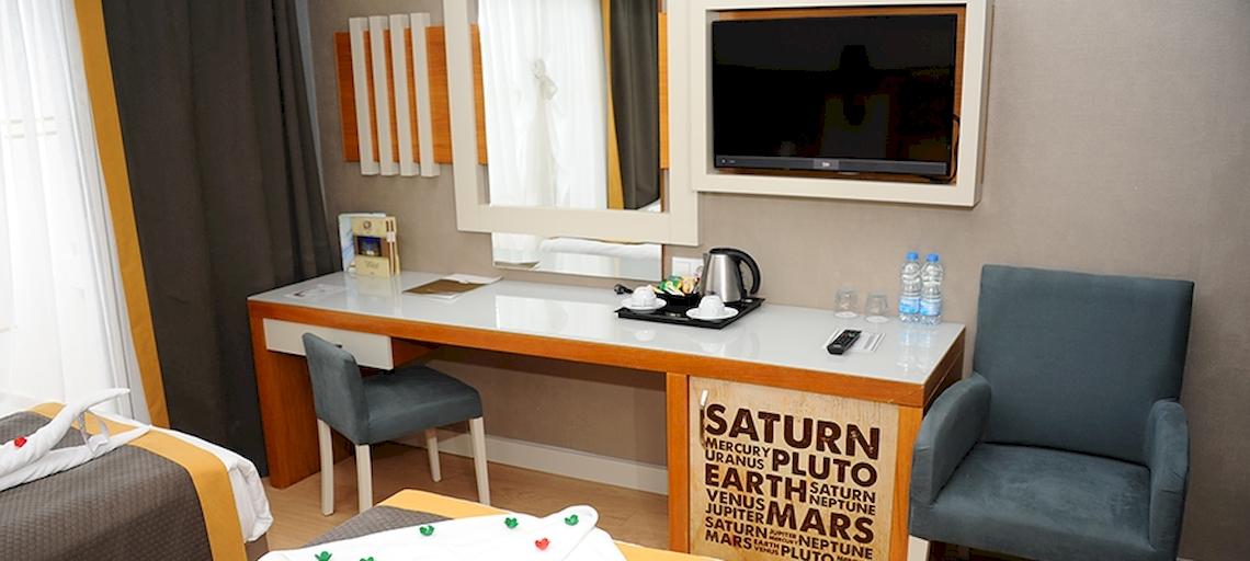 Hotelzimmer im Saturn Palace Resort mit Schreibtisch, Fernseher und Wasserflaschen