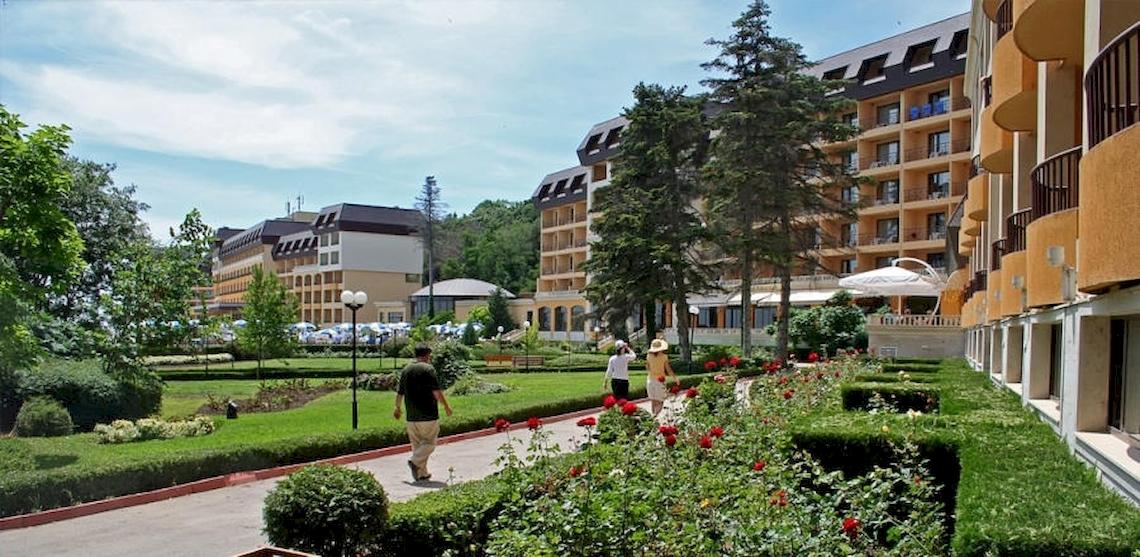 Riviera Beach Hotel Außenbereich mit mehreren Personen, die über einen gepflegten Rasenweg gehen.