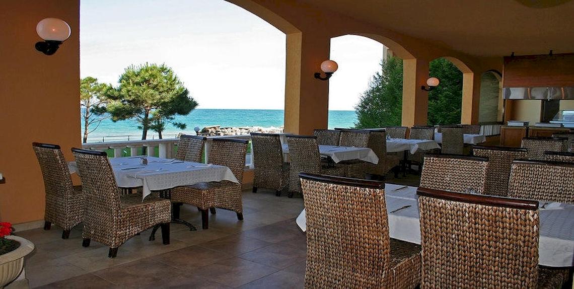Terrasse des Riviera Beach Hotels mit Blick auf das Meer und Bäume