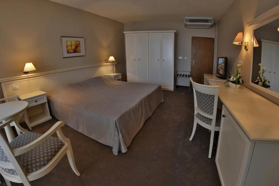 Ein luxuriöses Zimmer im Riviera Beach Hotel mit einem Bett, Möbeln und Dekoration.