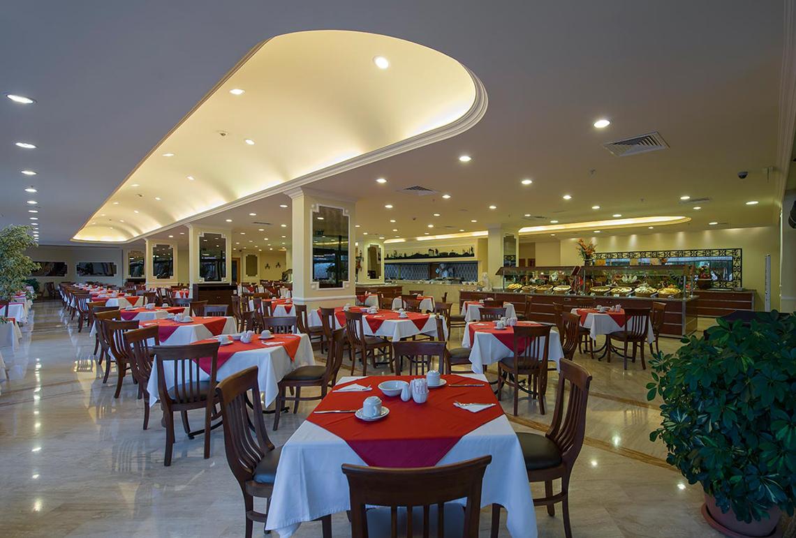 Innenansicht des Miramare Queen Hotel Restaurants mit vielen gedeckten Tischen und Stühlen.
