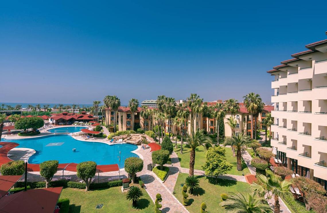 Außenansicht des Miramare Queen Hotels mit Swimmingpool und Palmen