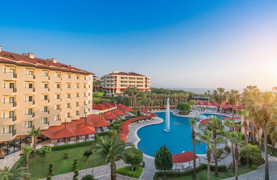 Außenansicht des Miramare Queen Hotels mit Swimmingpool und Sonnenschirmen
