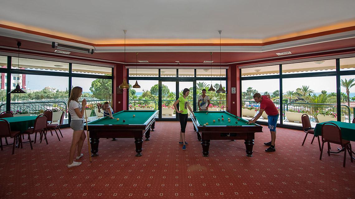Gruppe von Gästen spielt Billard im Poolbereich des Miramare Queen Hotels.