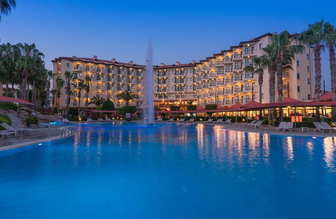 Außenpool und Hotel Miramare Queen bei Nacht, mit Palmen und beleuchteten Gebäuden