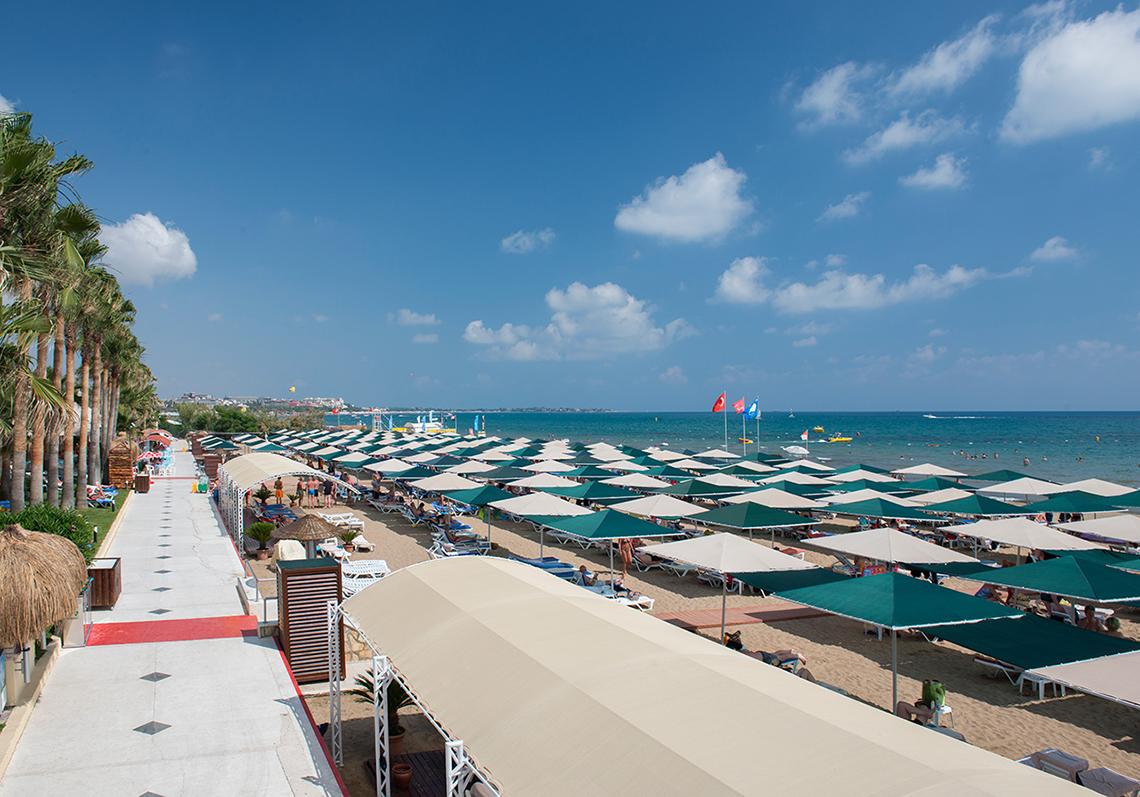 Strand mit vielen Liegen und Sonnenschirmen am Miramare Queen Hotel