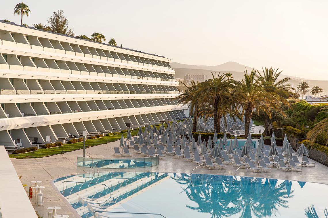 Außenansicht des Santa Monica Suites Hotels mit Swimmingpool und Sonnenliegen