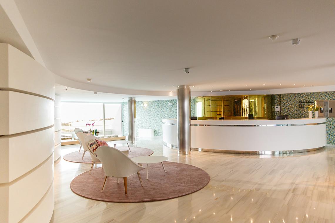 Empfangsbereich des Santa Monica Suites Hotels mit moderner Einrichtung und geschwungenen Wänden.