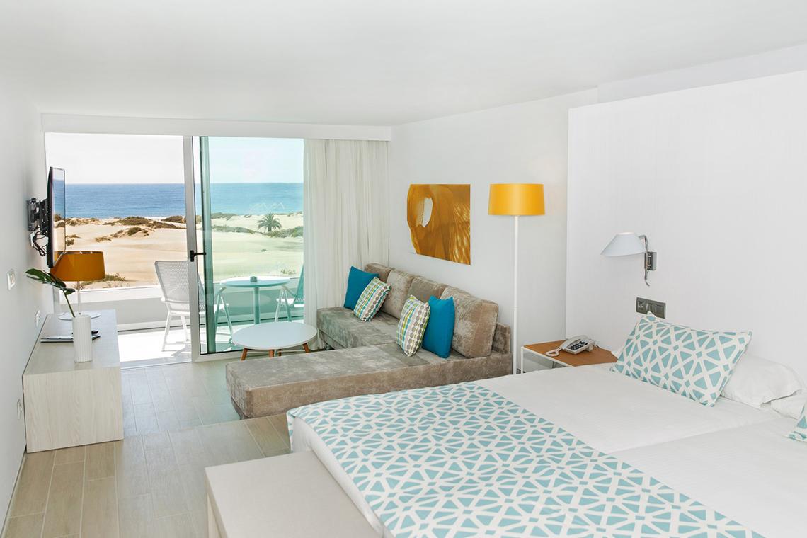 Zimmer im Santa Monica Suites Hotel mit Blick auf das Meer und einen Balkon.