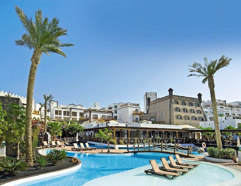 Außenbereich des Gran Castillo Tagoro Family & Fun Hotels mit Swimmingpool, Sonnenliegen und Palmen