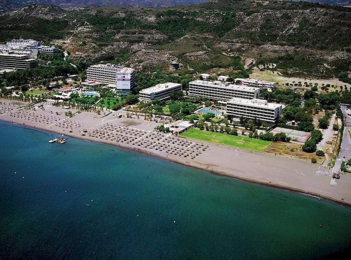 Luftaufnahme des Blue Sea Beach Resorts mit mehreren Gebäuden und einem langen Strand
