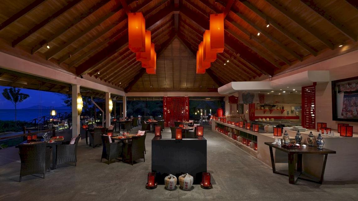 Innenbereich des Hilton Seychelles Labriz Resort & Spa mit Tisch, Stühlen und roten Laternen