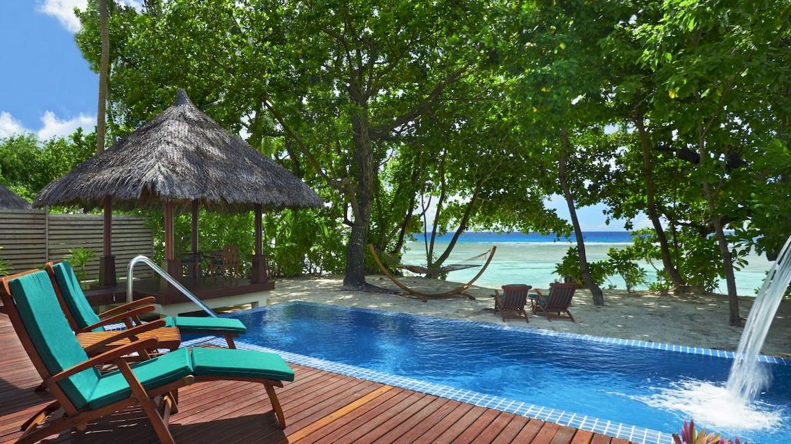 Außenpool des Hilton Seychelles Labriz Resort & Spa mit Lounge-Stühlen und einem Blick auf den Ozean.