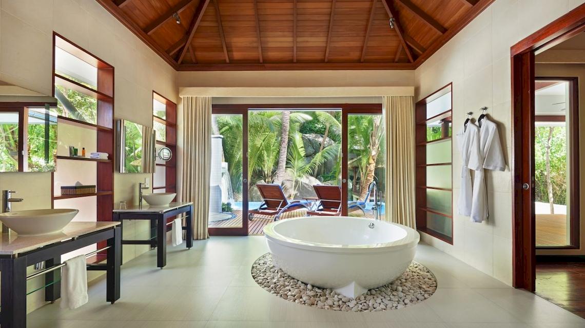 Ein Badezimmer im Hilton Seychelles Labriz Resort & Spa mit einer großen Badewanne und zwei Waschbecken.