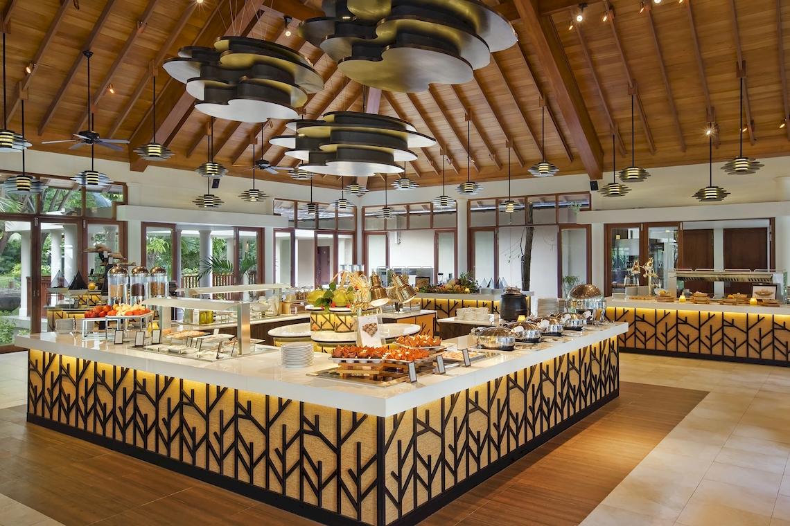 Buffetbereich im Hilton Seychelles Labriz Resort & Spa mit verschiedenen Speisen und tropischer Atmosphäre.