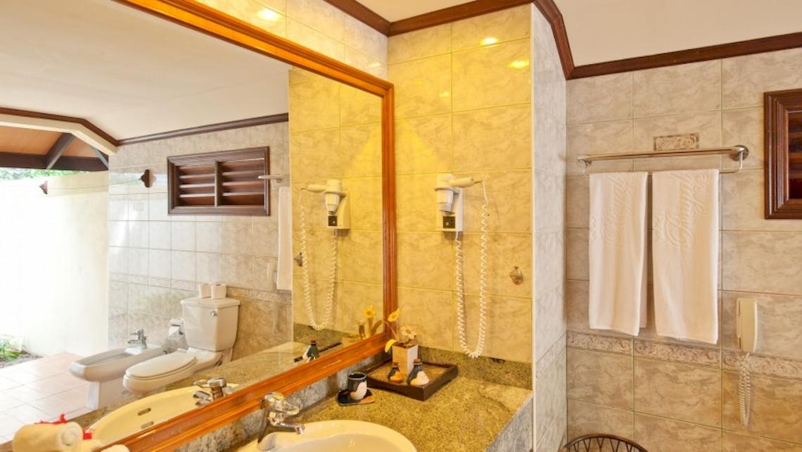 Badezimmer im Royal Island Resort & Spa mit großem Spiegel, Toilette, Bidet, Handtuchtrockner und Handtüchern.