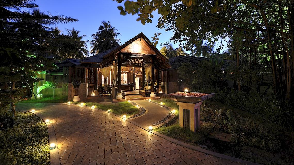 Das Royal Island Resort & Spa bei Nacht mit beleuchtetem Weg und Außenbeleuchtung.