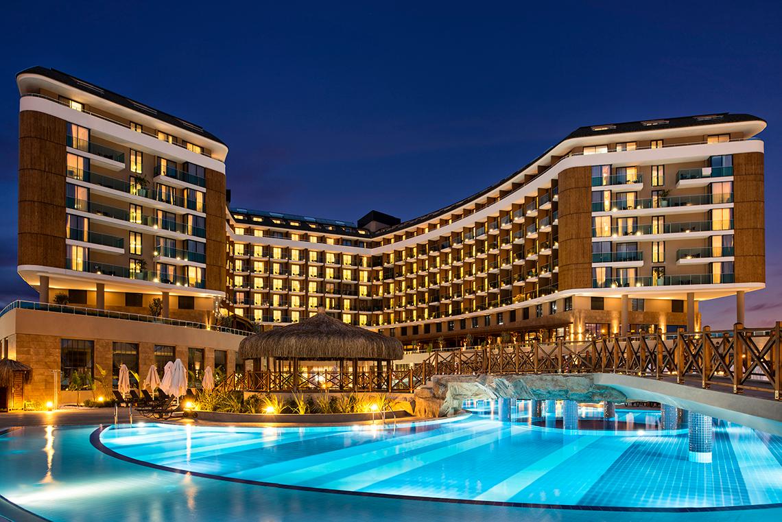 Aska Lara Resort & Spa bei Nacht mit beleuchtetem Swimmingpool und Hotelgebäude