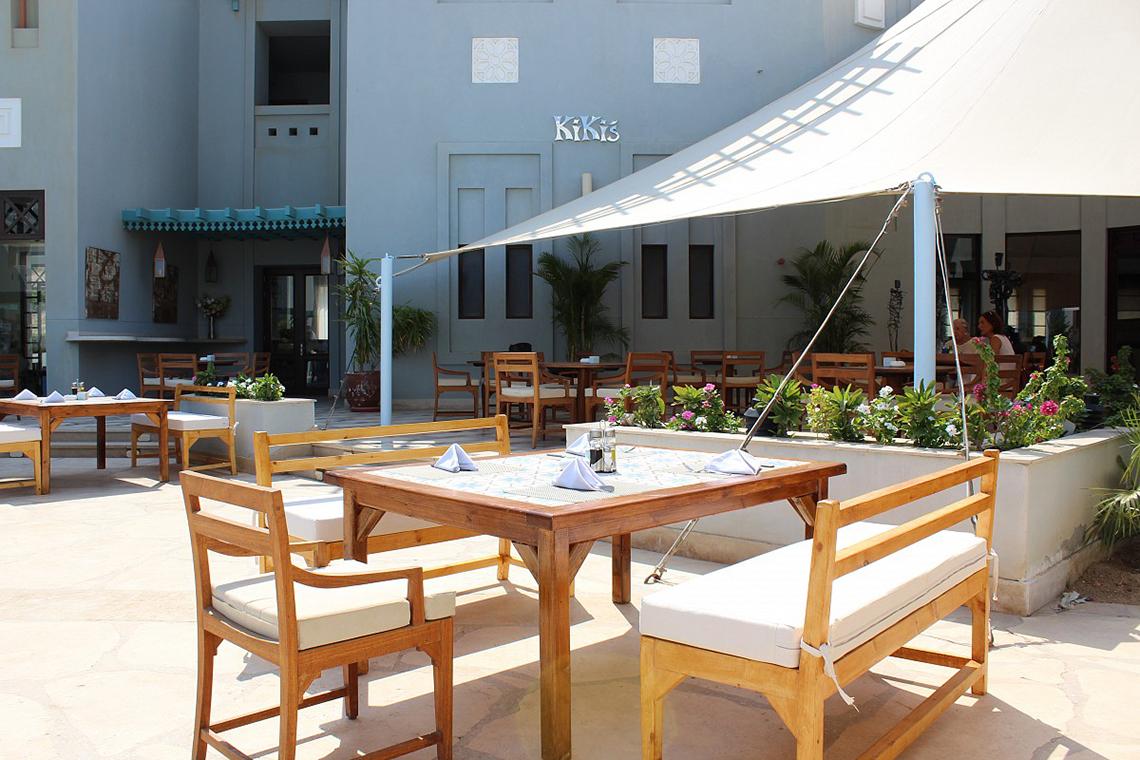 Terrasse des Fanadir Hotel El Gouna mit Tischen und Stühlen unter einem weißen Sonnensegel.