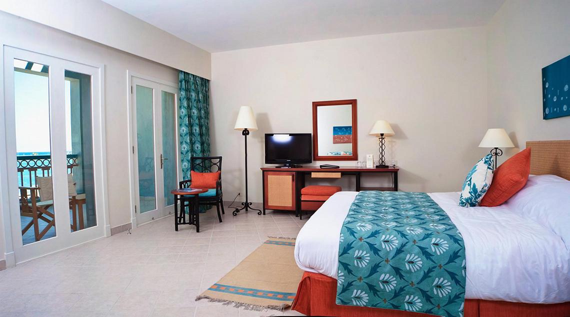 Zimmer im Fanadir Hotel El Gouna mit Meerblick, Bett, Schreibtisch, Fernseher und Möbeln.
