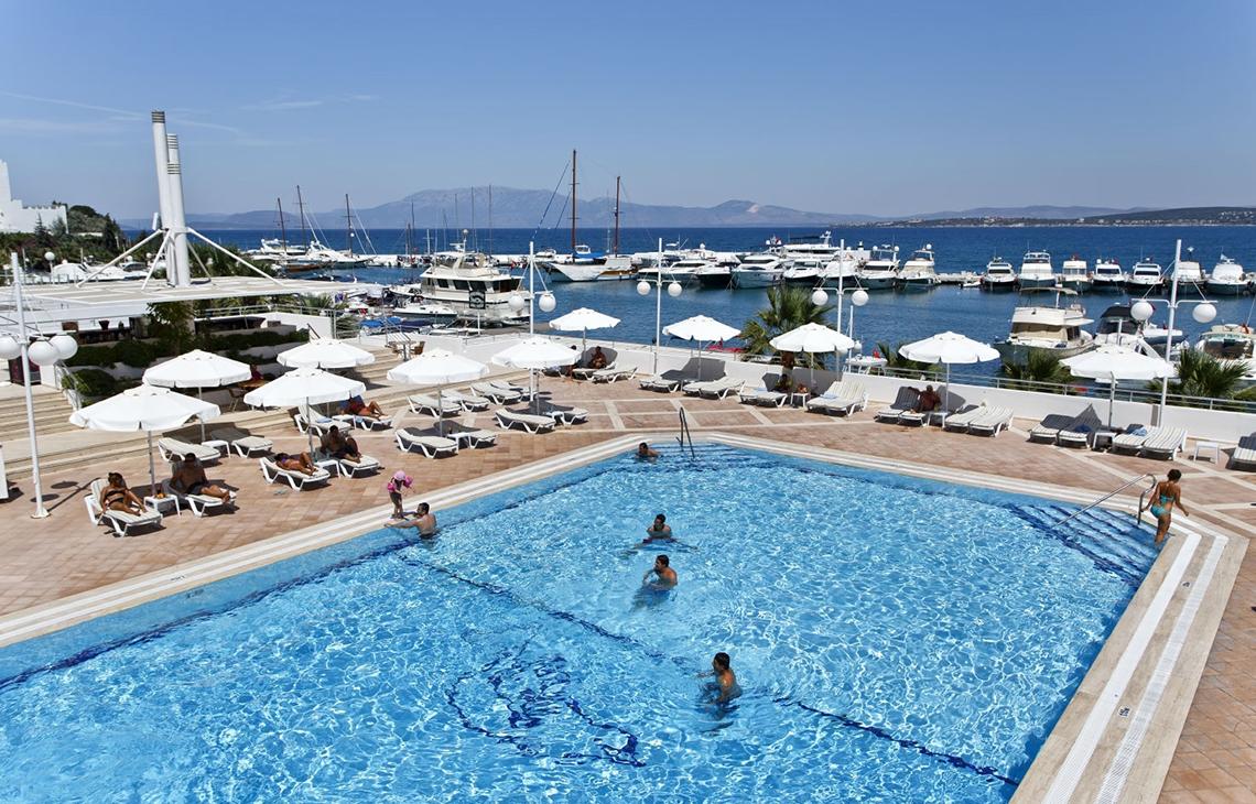 Poolbereich des Altin Yunus Hotel & Spa mit Gästen und Blick auf das Meer.