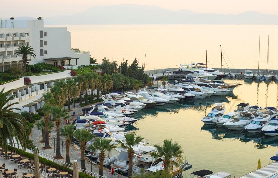 Außenansicht des Altin Yunus Hotel & Spa mit vielen geparkten Booten in der Marina.