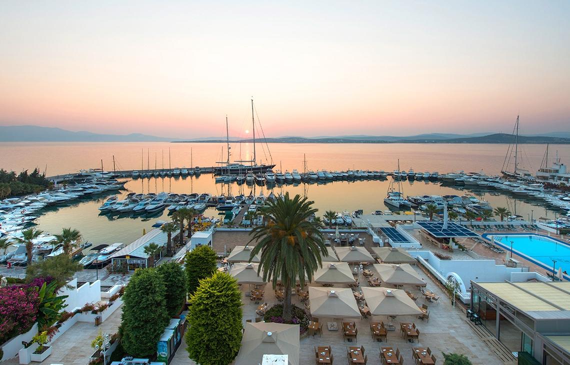 Luftaufnahme des Altin Yunus Hotel & Spa mit Blick auf den Hafen und Sonnenuntergang.