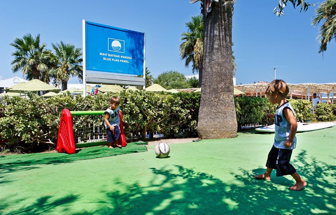 Zwei Kinder spielen Fußball vor dem Altin Yunus Hotel & Spa.