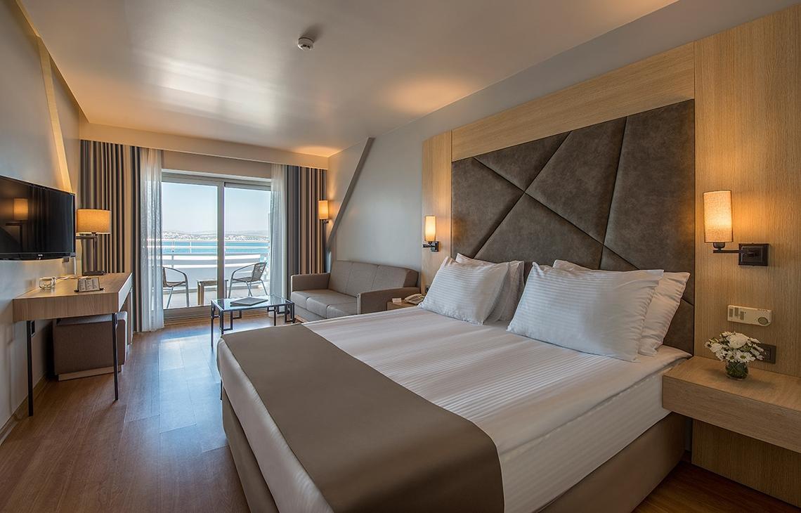 Innenansicht eines Zimmers im Altin Yunus Hotel & Spa mit Bett, Sofa, Fernseher und Aussicht.