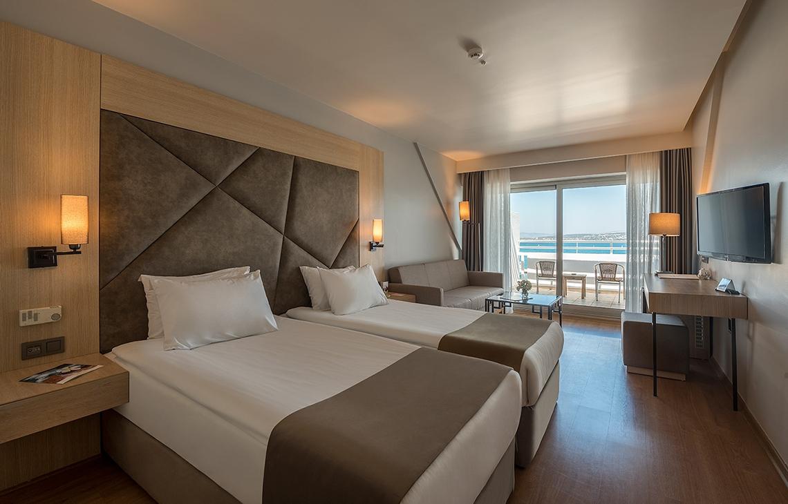 Hotelzimmer mit zwei Betten und Meerblick von der Terrasse.