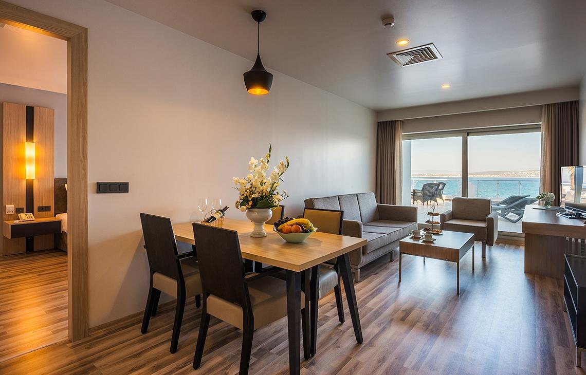 Wohnzimmer des Altin Yunus Hotel & Spa mit Tisch, Sofa und Meerblick.