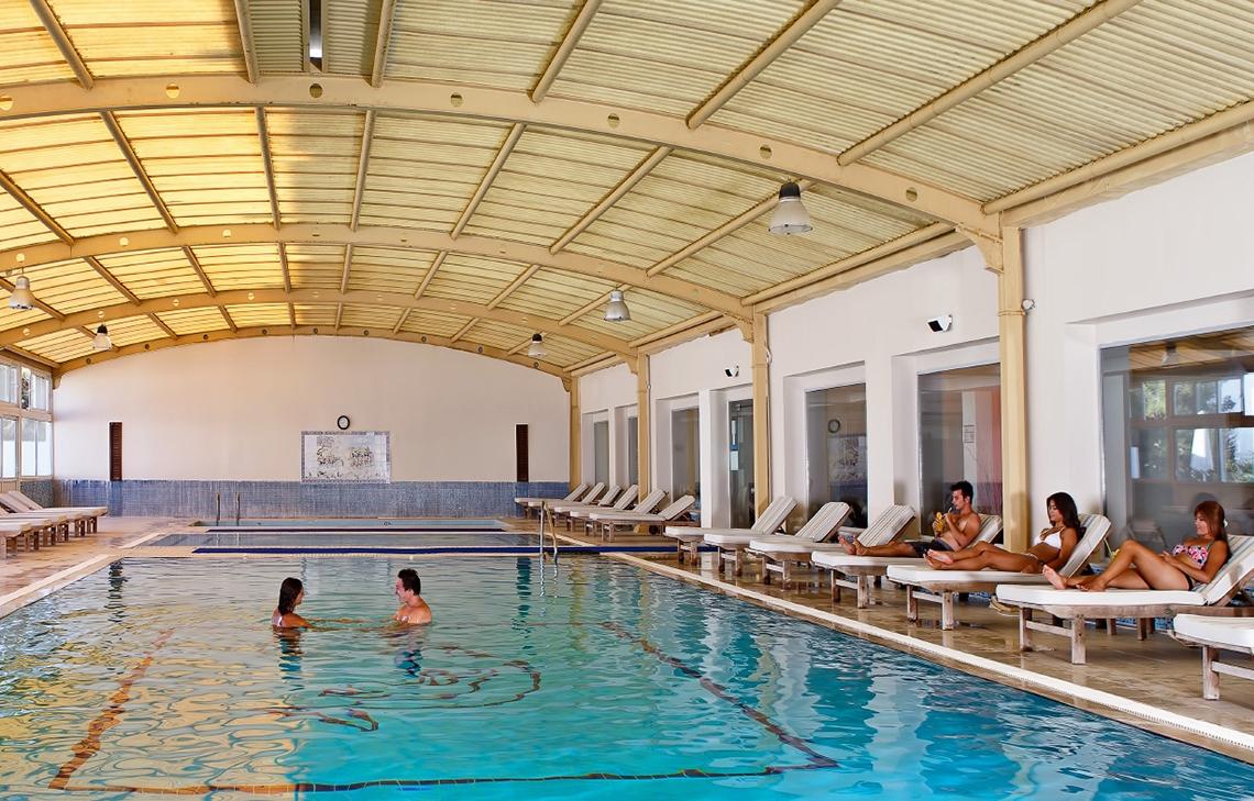 Schwimmbad im Altin Yunus Hotel & Spa mit mehreren Personen, die schwimmen und sich entspannen.