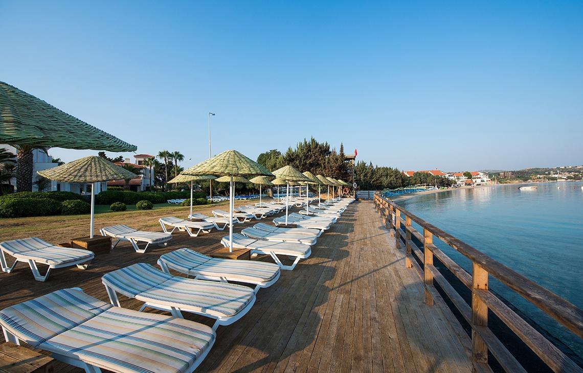 Reihe von Sonnenliegen auf der Strandpromenade des Altin Yunus Hotel & Spa