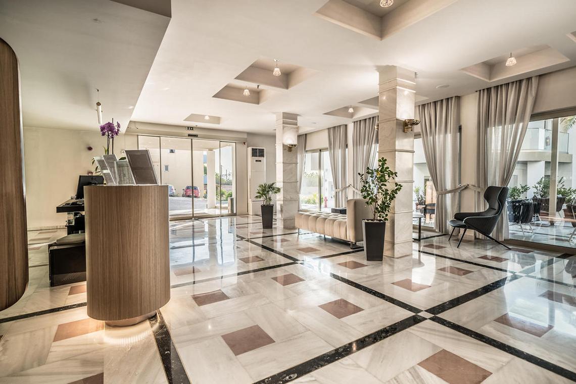 Empfangsbereich des Adele Beach Hotels mit Marmorboden und Sitzbereich.