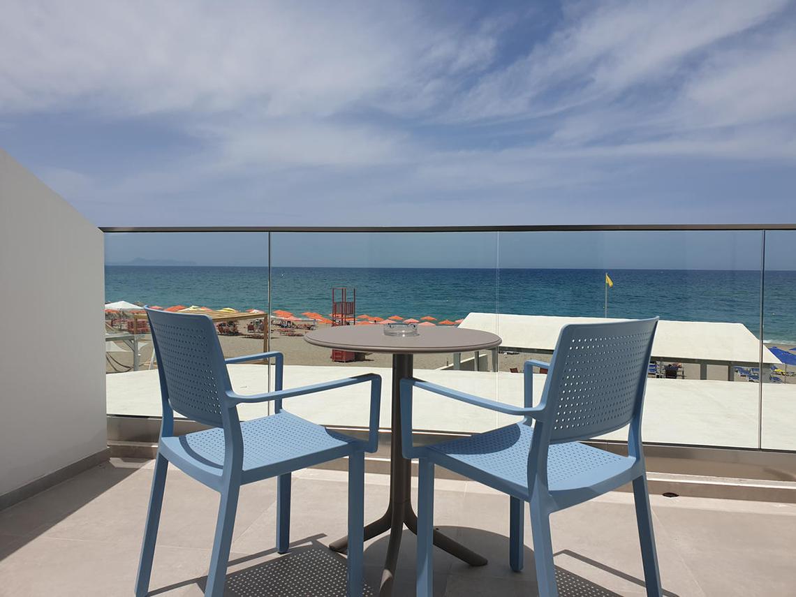 Balkon im Adele Beach Hotel mit Blick auf das Meer und eine gelbe Flagge.