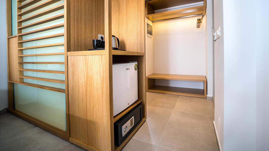 Ein Zimmerschrank im Adele Beach Hotel mit Minibar, Safe und Kaffeemaschine.
