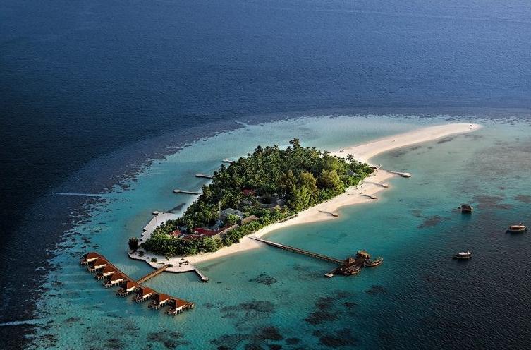Luftaufnahme des Nakai Maayafushi Resorts auf einer Insel mit weißen Stränden, grüner Vegetation und Wasservillen.