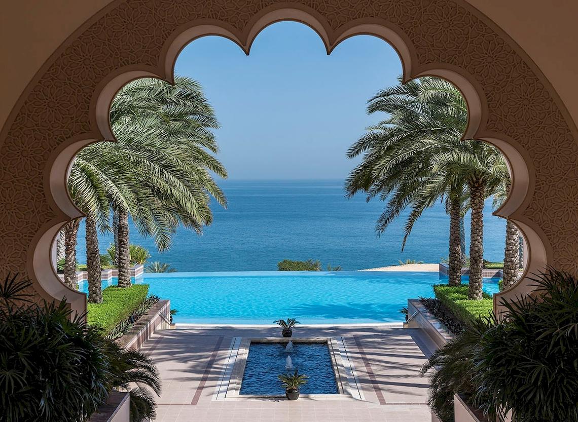 Ausblick von einem Pool mit Palmen und Meer im Shangri-La Al Husn Resort & Spa